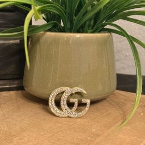 Bold gold-tone double “GG” brooch fully encrusted with sparkling rhinestones